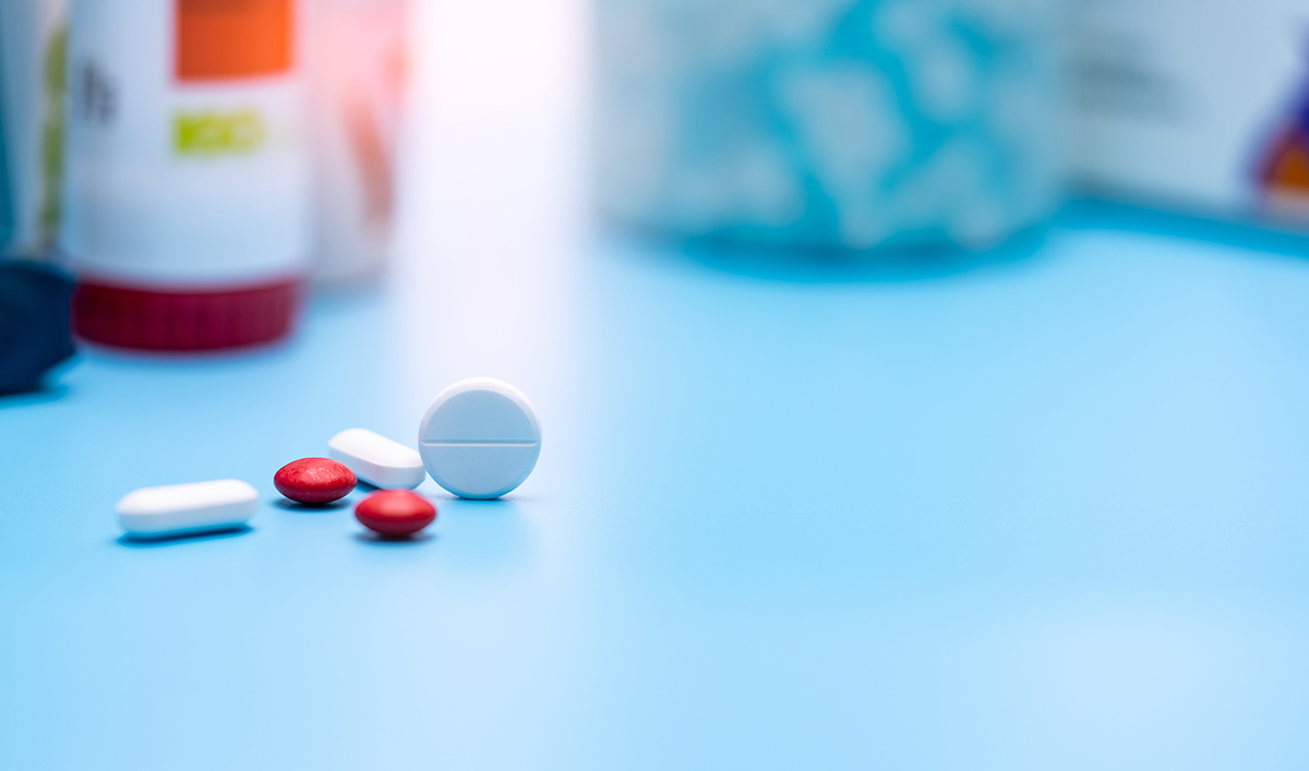 Tablets and medicine bottles on a blue bench